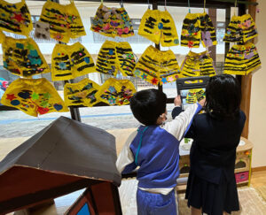 小学生が園児に撮影方法を教えている様子